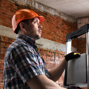 Hombre que lleva un casco de seguridad estilo gorra naranja para protección de la cabeza en trabajos de construcción