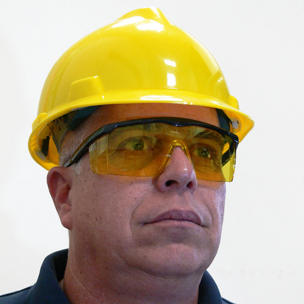 Hombre con una gorra amarilla estilo casco y las gafas de seguridad rectangulares con marco JORESTECH con protección UV y protectores laterales para protección contra impactos fuertes