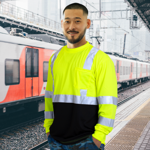 Trabajador en una estación de tren con camiseta de seguridad de manga larga, de alta visibilidad, reflectante y que disimula la suciedad