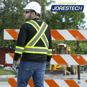 Un trabajador con camisa de seguridad JORESTECH® negra y amarilla con una X en la espalda, conforme a ANSI y CSA, y camisa de seguridad Birds Eye.