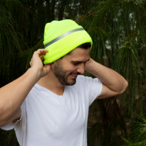 Un hombre usando el gorro beanie de seguridad JORESTECH color lima de alta visibilidad para aumentar la visibilidad