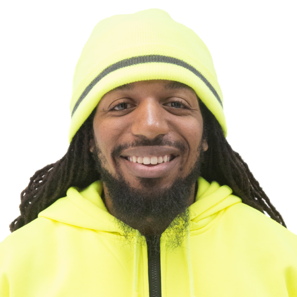 Un trabajador con el cabello muy largo llevando un suéter verde lima de alta visibilidad para combinar con el gorro beanie reflectante JORESTECH