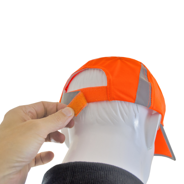 Primer plano de una mano tirando del cierre de gancho y bucle para ajustar el ancho de la gorra de seguridad naranja Hi-Vis JORESTECH
