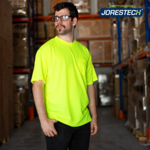 Hombre llevando la camiseta de seguridad JORESTECH de alta visibilidad amarilla/lima dentro de un almacén lleno de cajas marrones