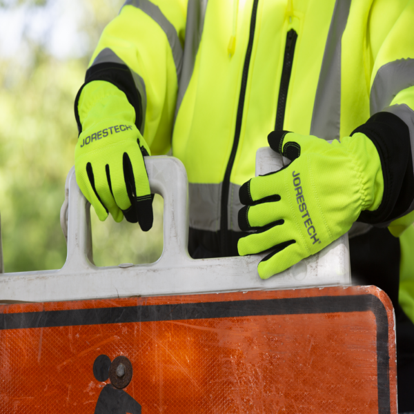 Persona usando guantes de trabajo de seguridad color lima para construcción vial