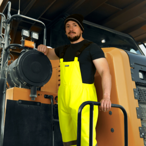 Trabajador usando el pantalón peto de alta visibilidad con franjas reflectantes