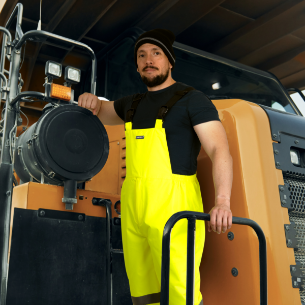 Trabajador usando el pantalón peto de alta visibilidad con franjas reflectantes