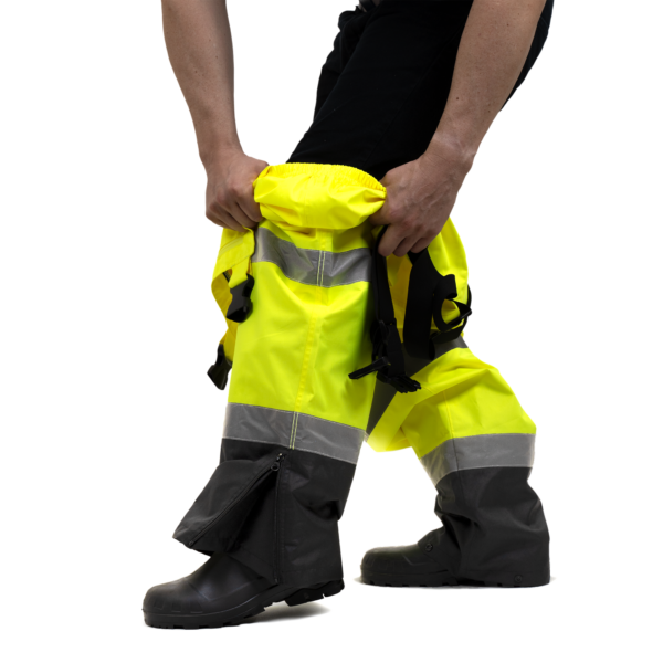 Primer plano de la abertura con cierre de cremallera en la bota de los pantalones de peto de seguridad de alta visibilidad