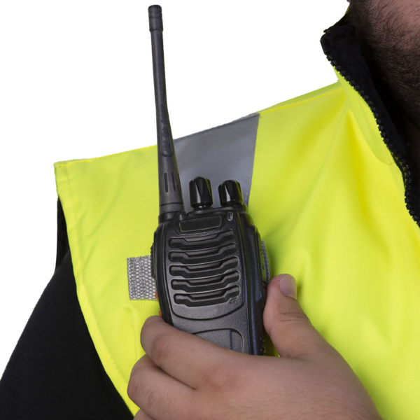 Primer plano que muestra las presillas para radio en el chaleco de seguridad reflectante aislado de color lima