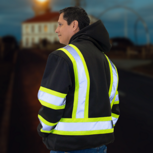 Hombre usando la sudadera con capucha de seguridad negra JORESTECH con franjas reflectantes en un entorno oscuro