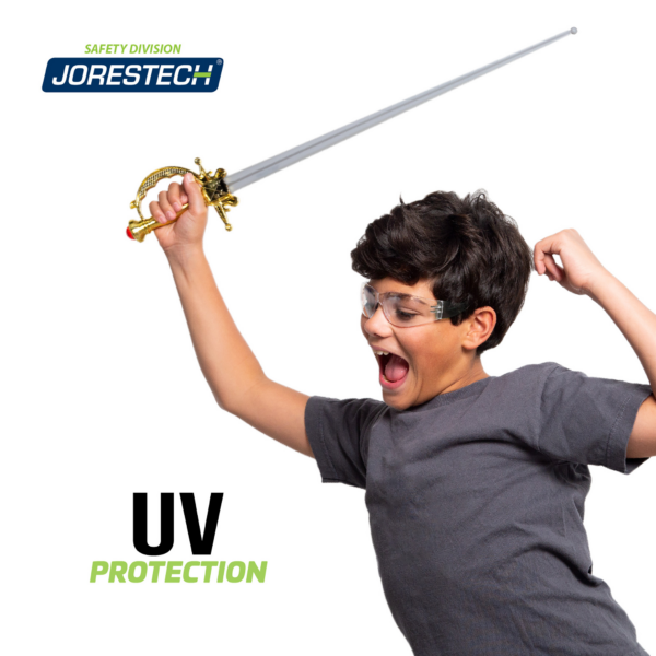 Un niño con gafas de seguridad jugando con una espada de plástico. Un banner con letras negras y verdes dice protección UV