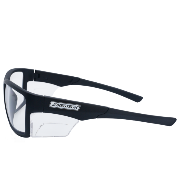 La imagen muestra una vista lateral de unas gafas de seguridad JORESTECH con protector lateral transparente para protección contra impactos fuertes. Estas gafas de seguridad con protectores laterales transparentes cumplen con ANSI y tienen montura negra y lentes de policarbonato transparente. El fondo de la imagen es blanco