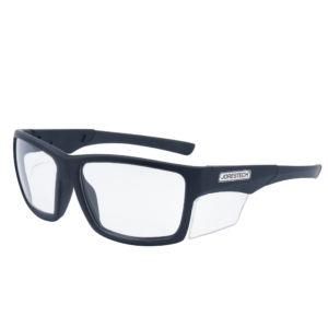 La imagen muestra una vista diagonal de unas gafas de seguridad transparentes JORESTECH con protector lateral transparente para protección contra impactos fuertes. Estas gafas de seguridad cumplen con la norma ANSI y tienen montura negra y lentes transparentes de policarbonato. El fondo de la imagen es blanco