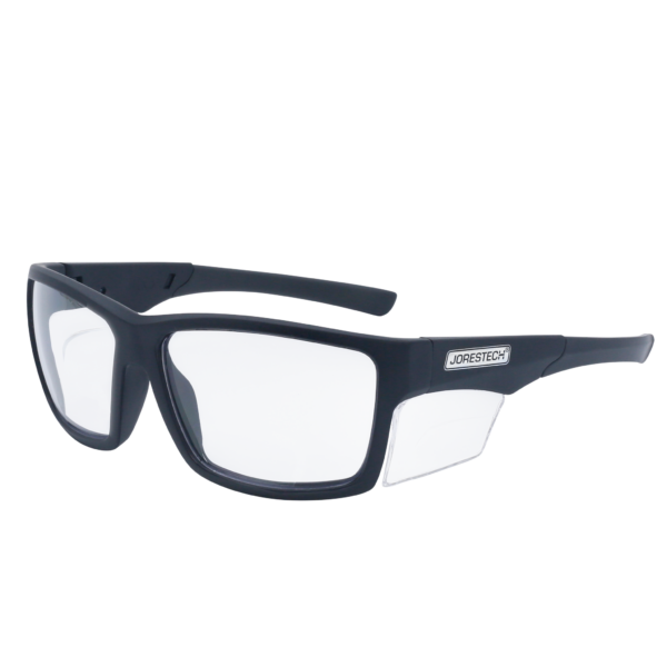 La imagen muestra una vista diagonal de unas gafas de seguridad transparentes JORESTECH con protector lateral transparente para protección contra impactos fuertes. Estas gafas de seguridad cumplen con la norma ANSI y tienen montura negra y lentes transparentes de policarbonato. El fondo de la imagen es blanco