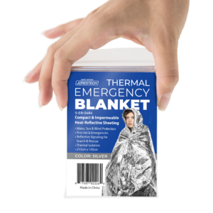 Mano de una persona sosteniendo una manta de emergencia Thermafoil en su bolsa con cierre hermético, con una etiqueta que dice: lámina compacta e impermeable reflectante del calor para protección contra el agua, el sol y el viento.