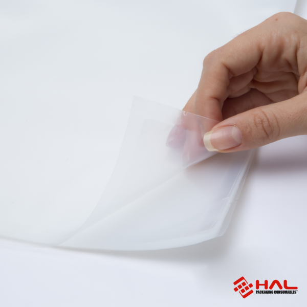 Imagen de las manos de una mujer abriendo una bolsa transparente para mostrar el material de las bolsas para selladora al vacío HAL sobre fondo blanco