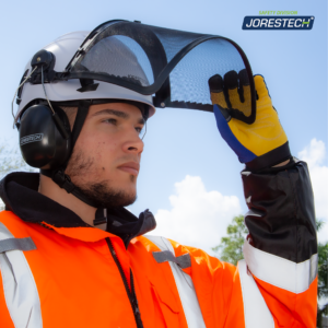 Un hombre que lleva el casco de seguridad ventilado blanco Jorestech con mentonera, la pantalla facial de malla de hierro y los protectores auditivos acoplados. Está levantando la pantalla facial para mostrar cómo pivota fácilmente y se aparta del camino.