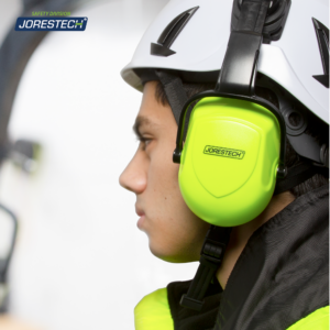 Un trabajador con un casco de seguridad blanco ventilado con orejeras lima montadas en un entorno de construcción